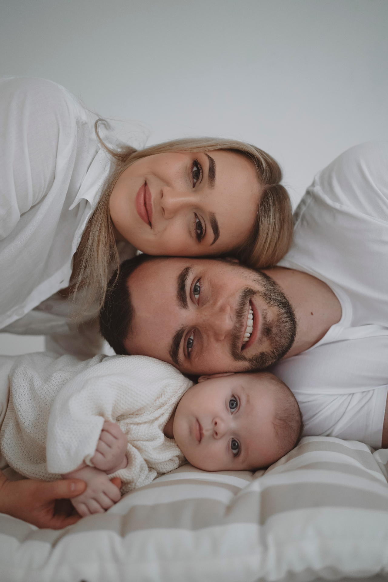 Rodina s miminkem v objetí na posteli